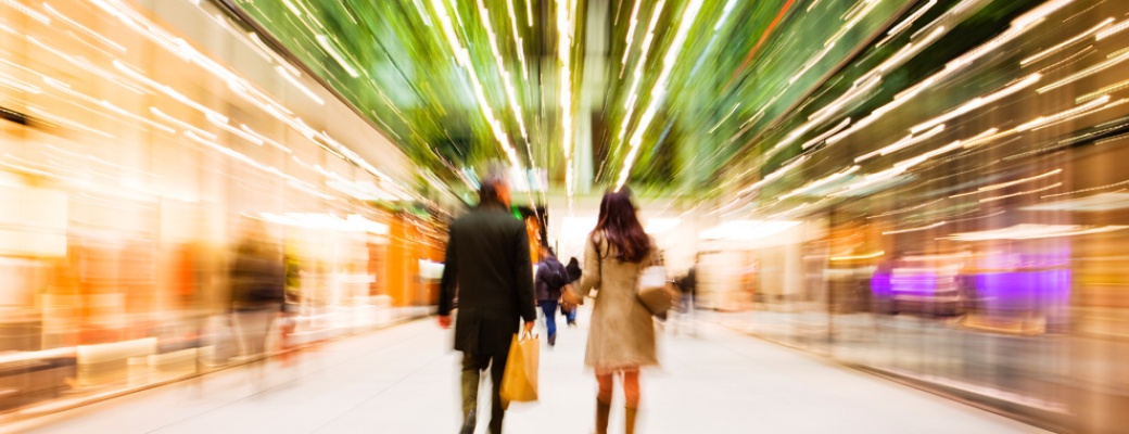 Shoppers walking through a brightly lit shopping centre